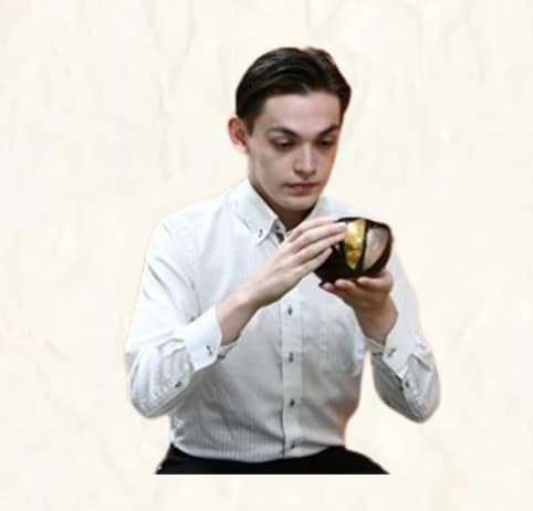 A man is drinking a bowl of matcha tea.