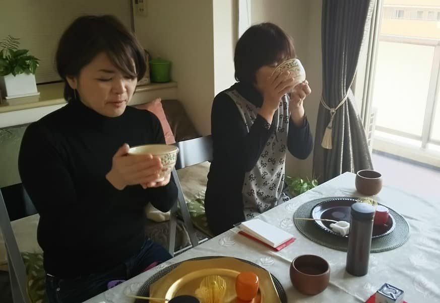 自宅のテーブルで茶の湯の稽古をする女性2名